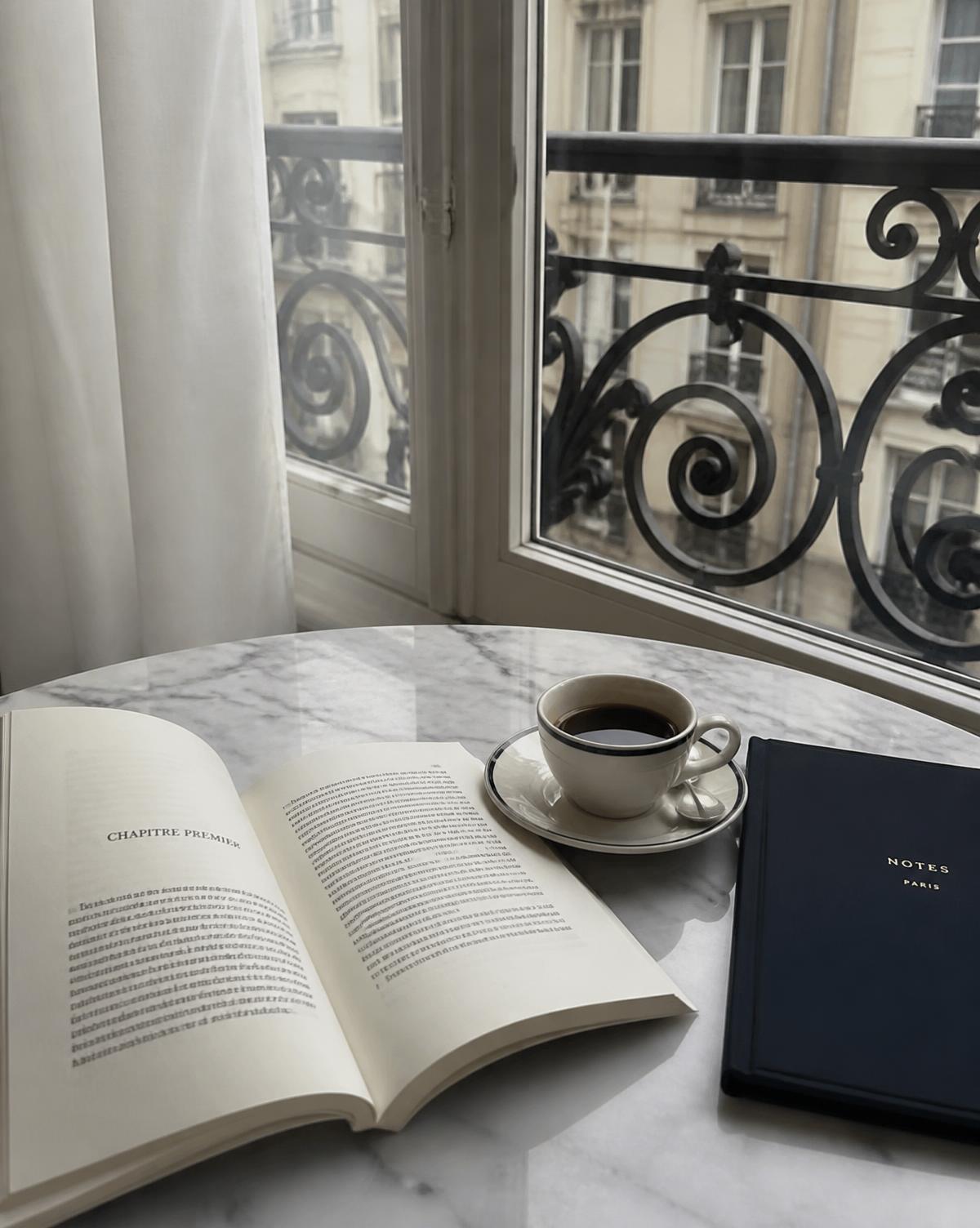Livro em francês e caderno sobre mesa de mármore em um apartamento parisiense
